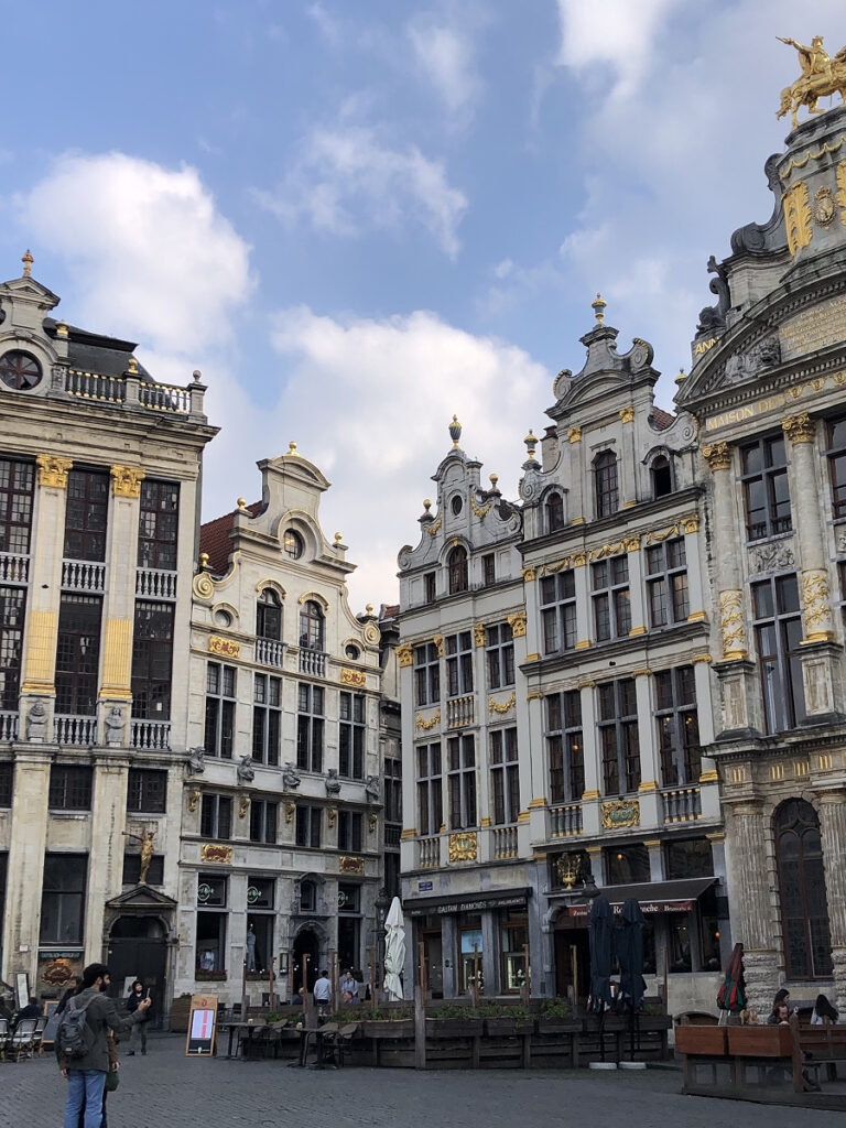 Elegant Baroque guildhalls in the Grand Place, Brussels' iconic main square, with golden architectural details under a partly cloudy sky