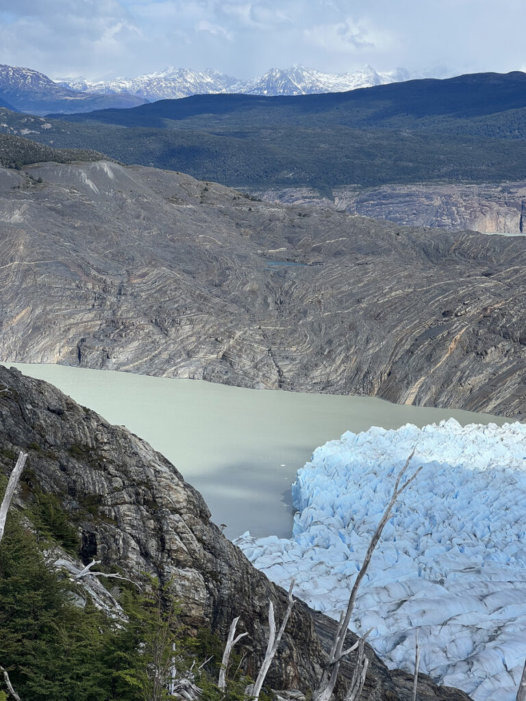 View of Grey Glacier from above, with turquoise water and jagged ice contrasting against rugged mountains on the Patagonia O Trek in Torres del Paine