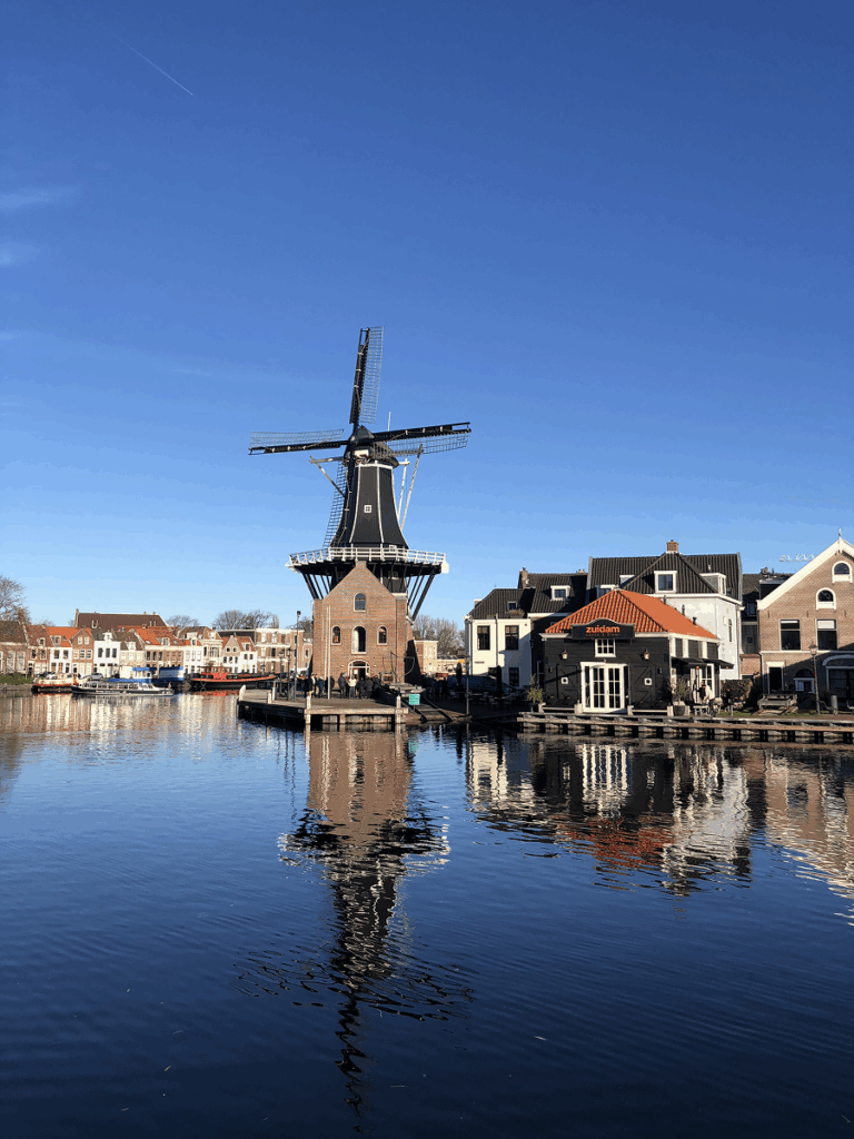 Molen de Adriaan windmill on the Spaarne River in Haarlem on a clear day — a scenic day trip from Amsterdam in the Netherlands