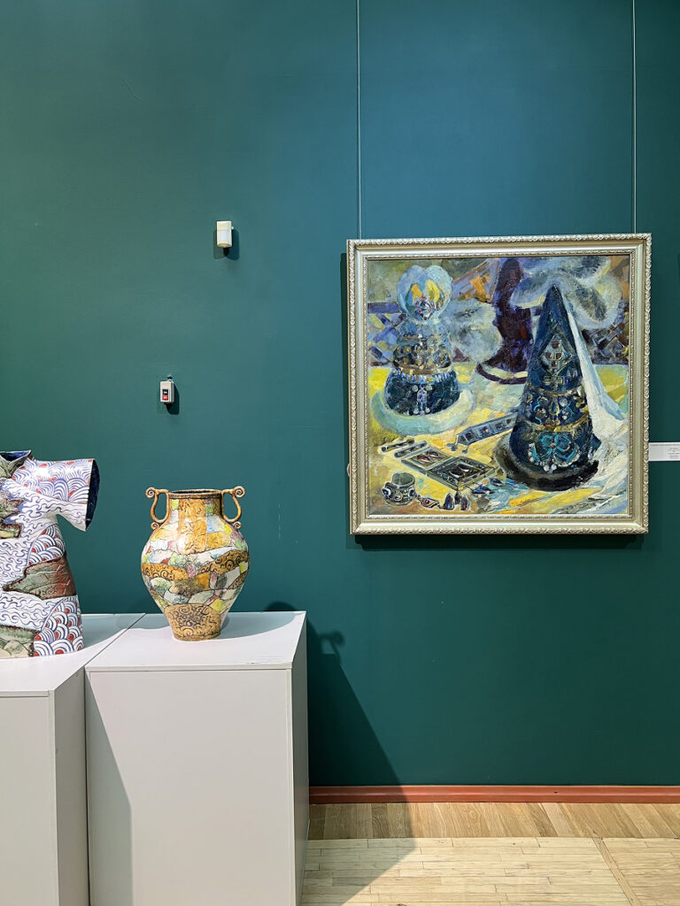 Interior of the Kasteyev State Museum of Arts in Almaty featuring a Kazakh painting and colorful ceramic vases