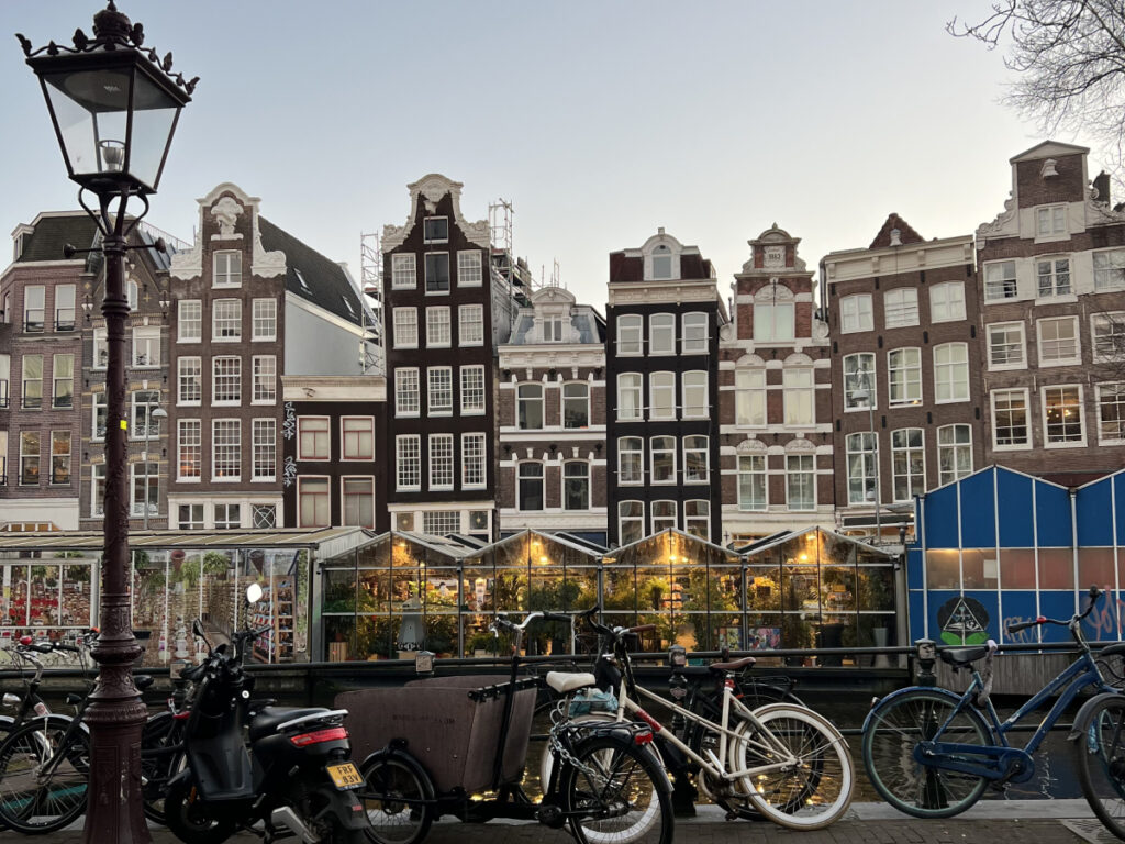 Traditional canal houses and parked bikes at sunset in Amsterdam