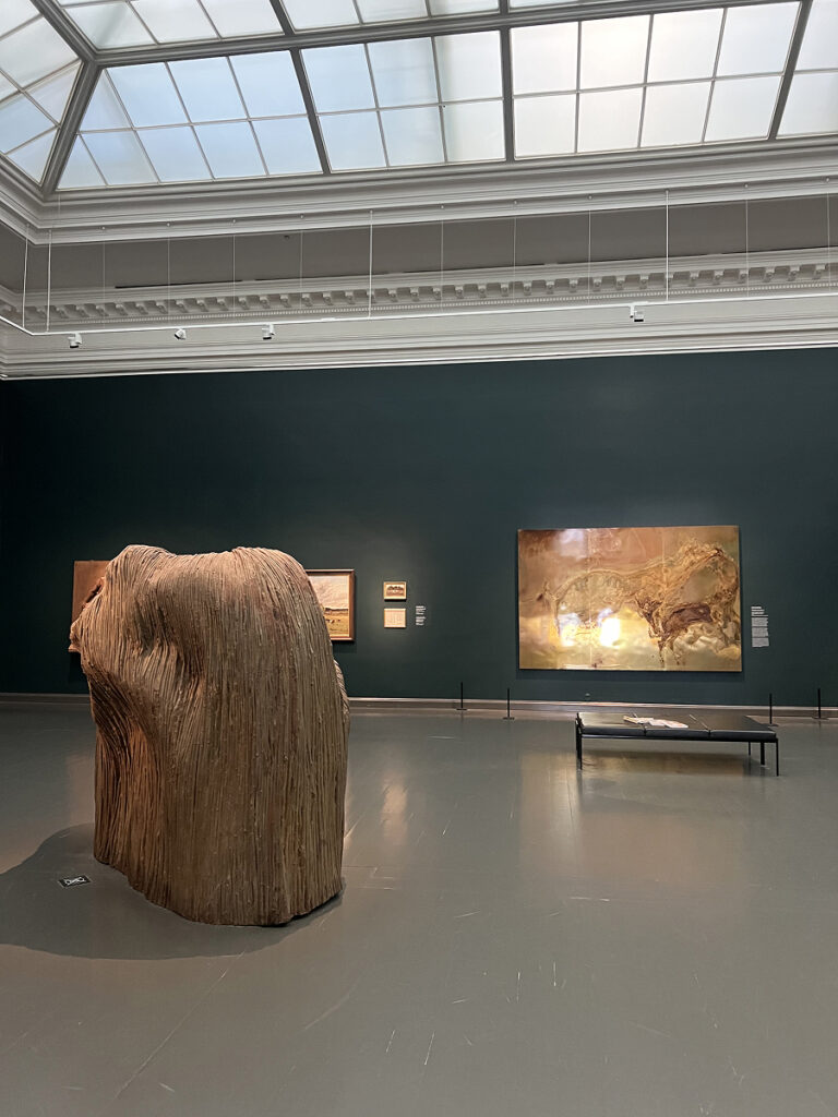 Exhibit inside the Ateneum Art Museum in Helsinki, featuring a large contemporary sculpture and paintings displayed under a glass ceiling.