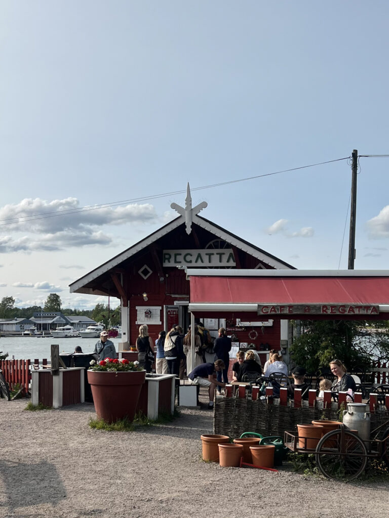 Exterior of Café Regatta in Helsinki, Finland, with outdoor seating by the waterfront on a sunny day.