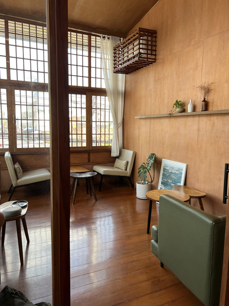 Quiet, minimalist cafe interior in Chiang Mai with soft lighting, wooden walls, and cozy seating — a peaceful place to work or unwind.