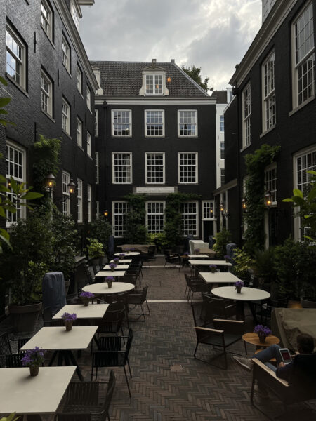 Courtyard at The Dylan Amsterdam on a cloudy day with outdoor seating