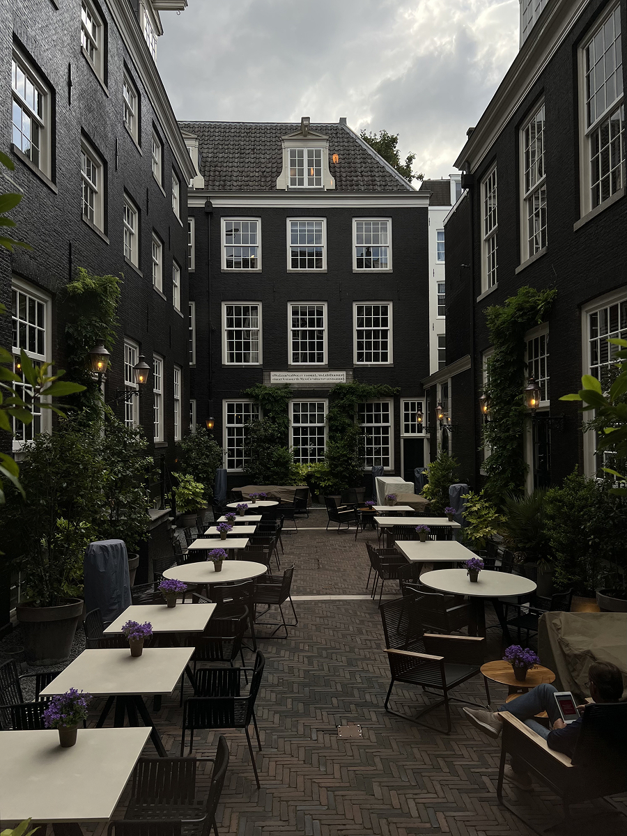 Courtyard at The Dylan Amsterdam on a cloudy day with outdoor seating
