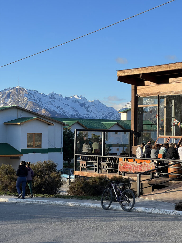 Street view of El Chaltén with restaurants and snowy peaks in the background, Patagonia Argentina.
