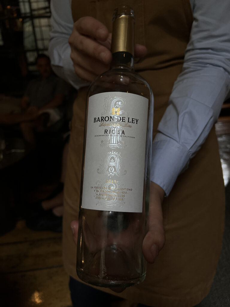 Waiter presenting a bottle of Baron de Ley white wine during High Wine at The Dylan Amsterdam