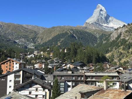 View of the Matterhorn from Hotel Capricorn Zermatt balcony overlooking the alpine village rooftops.
