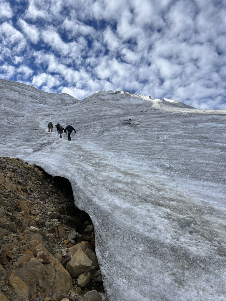 Climbers making their way up the icy glacier of Nevado Mateo beneath a striking Andean sky