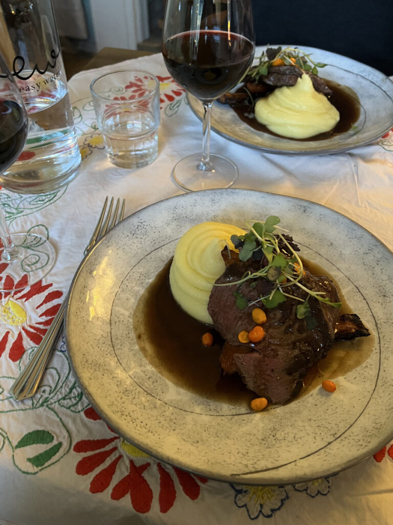 Traditional Finnish reindeer dish served with mashed potatoes, cloudberries, and red wine at a restaurant in Helsinki.