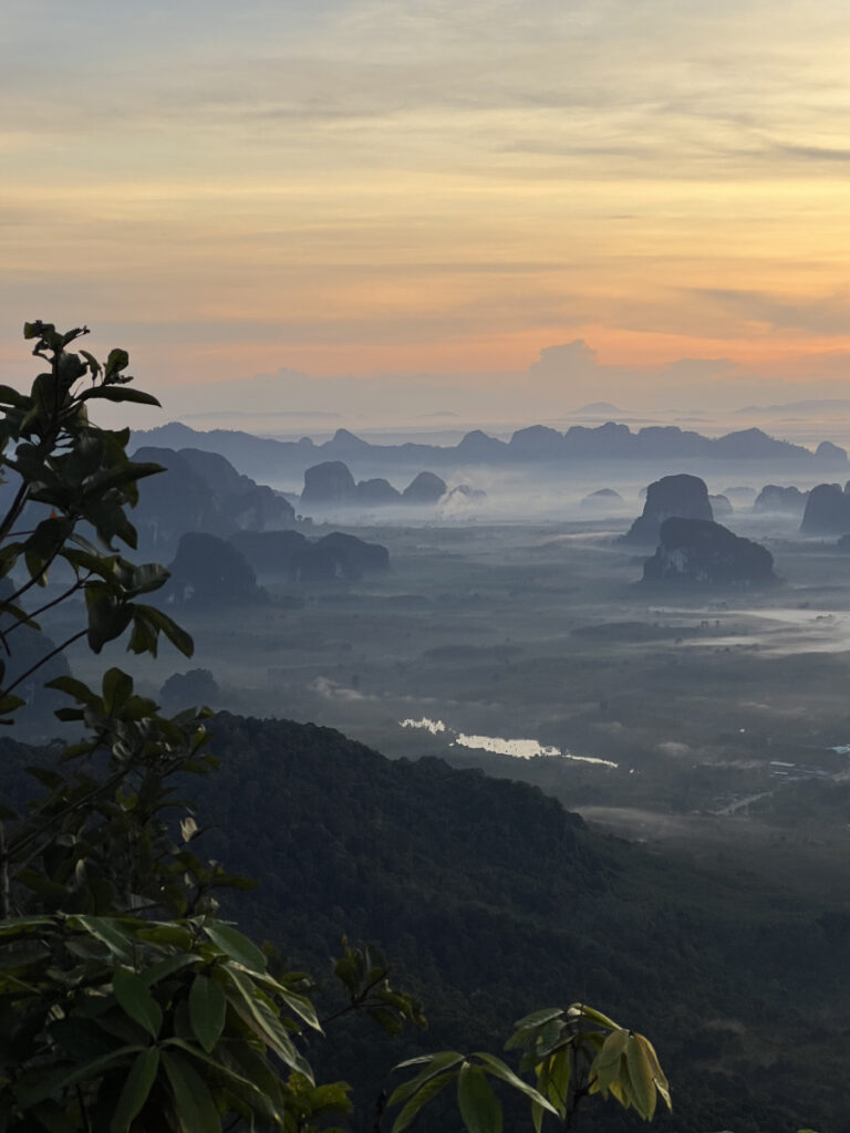 Sunrise view from Khao Ngon Nak trail in Krabi, Thailand, with misty limestone cliffs and jungle landscape