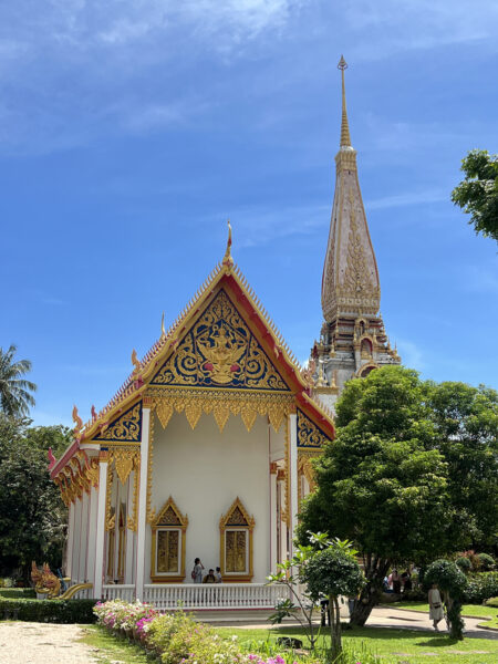 Ornate temple at Wat Chai Thararam in Krabi, Thailand, on a sunny day with blue skies and lush greenery