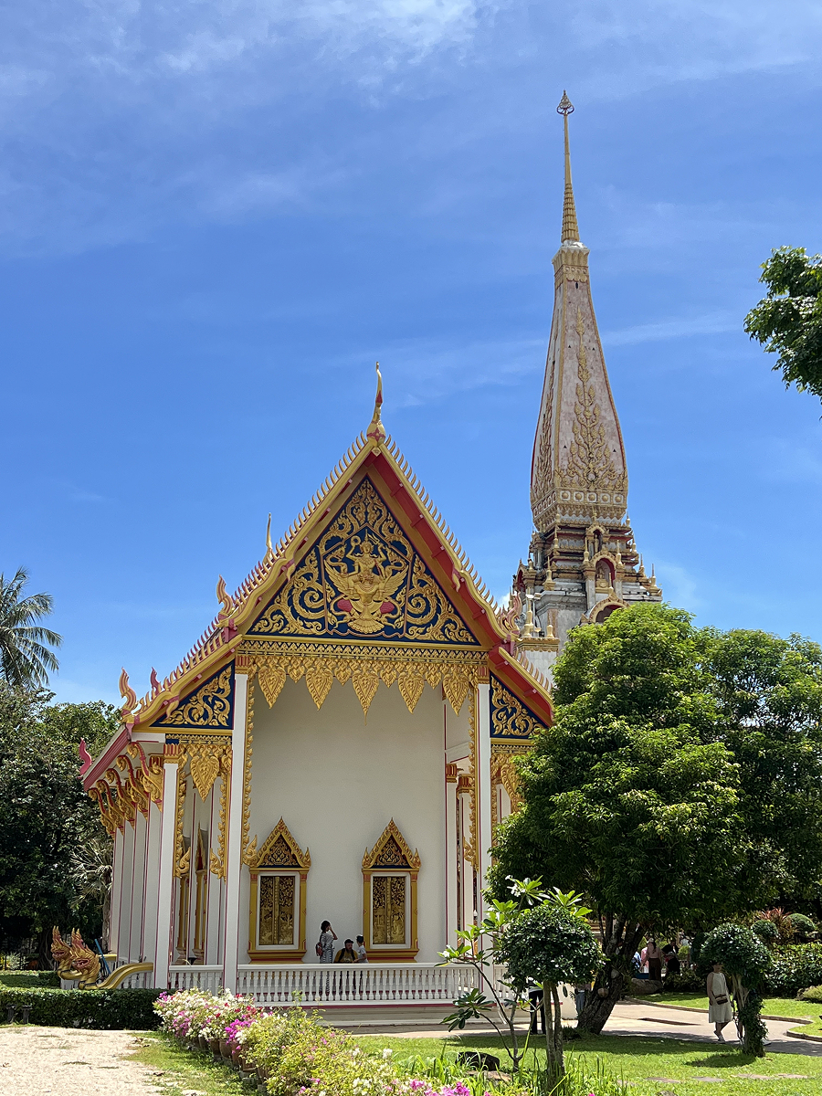 Ornate temple at Wat Chai Thararam in Krabi, Thailand, on a sunny day with blue skies and lush greenery